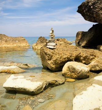 A stack of stones by the sea in a cove